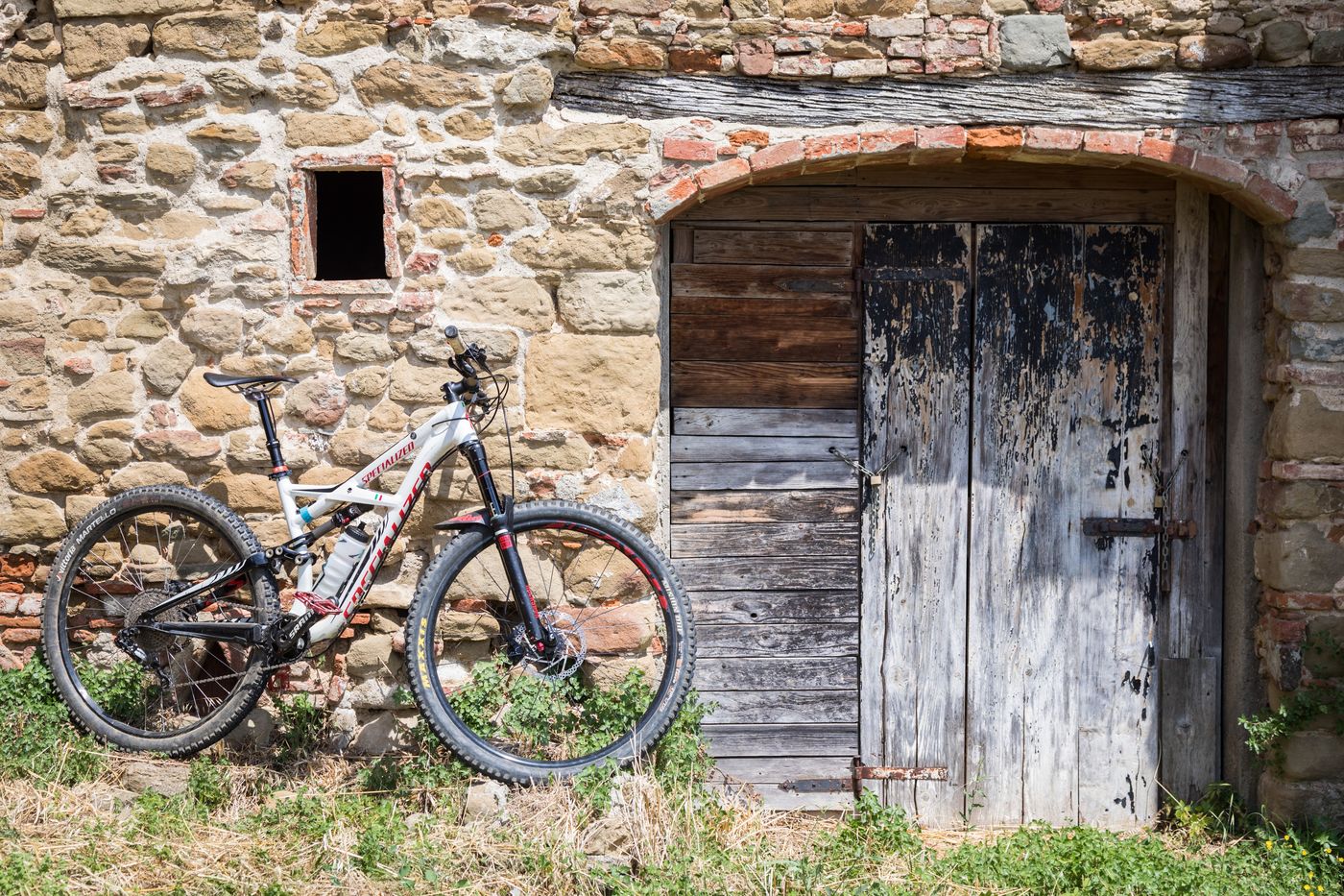 MTB appoggiata a un casale in pietra sul Montalbano